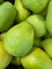 Close-up photo of pomelos in market. Group of fruits background.