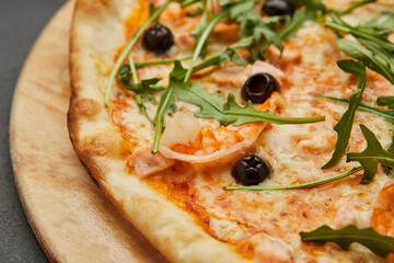 Delicious Italian seafood pizza on dark background