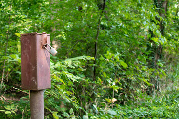 donation box with padlock along path in the woods
