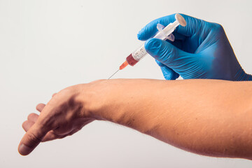 Hand in glove with syringe on white background.