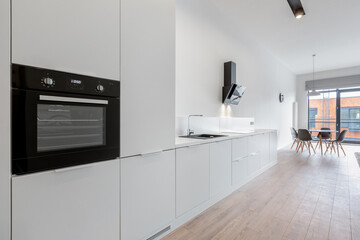 Spacious white kitchen with wooden floor