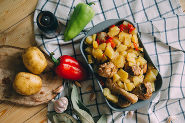 Baked chicken legs with potatoes and bell peppers on a baking sheet