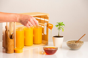 Hand dripping CBD honey, marijuana plant and hemp seeds