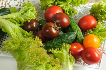 MIx raw seasonal vegetables. Different varieties of tomatoes, cucumbers, lettuce. Weight loss, vegetarian diet concept. Selective focus