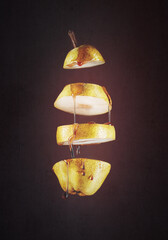 pear cut with honey or runny maple syrup, dark background, illustration, photomontage, graphics and food photography