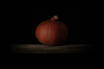 pumpkin orange in moody style, soft light with shadow on black background, mystical and dramatic scene, ideal for graphic backgrounds with text space - 378602382