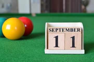 September 11, number cube with balls on snooker table, sport background.