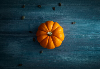 Orange pumpkin on blue wooden background top view, ideal for backgrounds, layouts and Template

