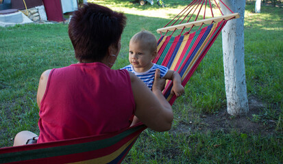 a little girl on a hammock with her grandmother