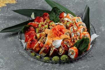 Sushi rolls set on a crystal tray. Rolls: Philadelphia, Green Dragon, Hawaii, Red Dragon, Ebi Shake