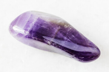 closeup of sample of natural mineral from geological collection - polished Amethyst rock on white marble background from Namibia