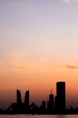 Fototapeta na wymiar Bahrain skyline with iconic buildings at dusk with dramatic hue in sky