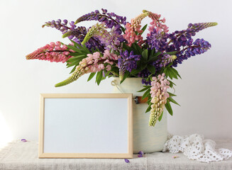bouquet of pink and purple peonies and an empty rectangular frame