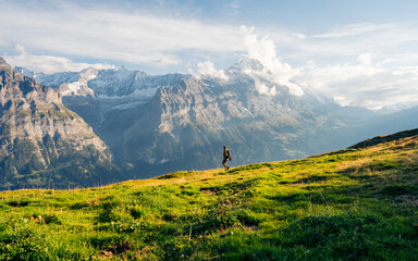 Hiker on the The Eiger trail and The Eiger, a 3,967-metre mountain of the Bernese Alps, overlooking...