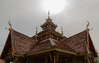 Ancient wooden roof on Buddhist temple in Wat Pratu Pong at Lampang Province. Beautiful temple built in a mix of Lanna and Burmese Shan styles. Selective focus.