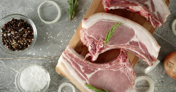 Raw pork escalope with rosemary and onions on the table. 