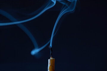 Smoke from an extinguished candle on a dark background.