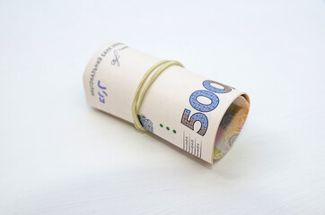 large bills Ukrainian hryvnia in elastic on white