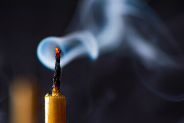 Smoke from an extinguished candle on a dark background.