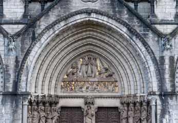 Sculptures above the portal, on the façade of St Finn Barre's Cathedral in Cork, Ireland, built in the 19th  century in Gothic Revival style. 