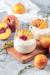 Yoghurt with fresh peaches on light background