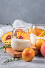 Yoghurt with fresh peaches on light background