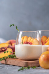 Yoghurt with fresh peaches on light background