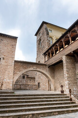 Romantic street with stone arch decorated with plants Spello, Umbria, Italy