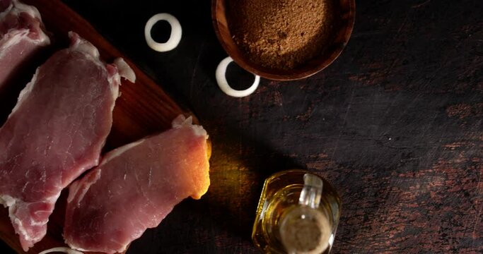 Raw pork escalope on a cutting board with spices. 