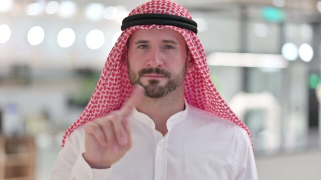 Serious Arab Businessman saying No by Finger Sign