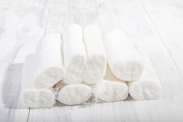 A white wooden background in retro style on it lies a bunch of medical bandage, the shape of a pyramid.