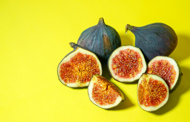 Fresh ripe figs on a yellow background. Sweet sliced figs on the table. View from above. Copy space.