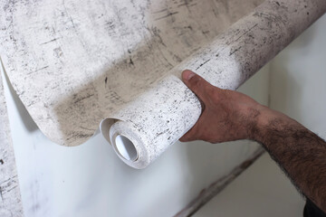 Close-up of a painter gluing Wallpaper to the wall. The concept of repair