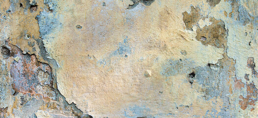 Old cracked weathered painted wall background texture. Light peeled plaster wall with falling off flakes of paint