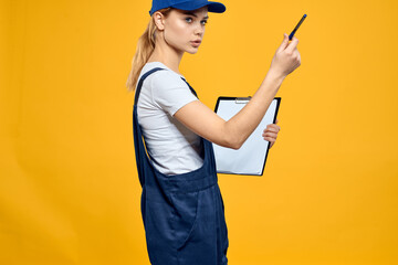 woman in work uniform documents courier service yellow background