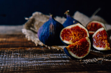 several figs whole and chopped on an old wooden table, copy space