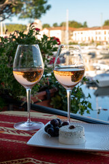 Tasting of local rose wine and soft french goat cheese in summer with sail boats haven of Port Grimaud on background, Provence, France