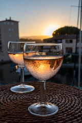 Drinking of local rose wine at sunset with sail boats haven of Port Grimaud on background, Provence, France