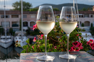 Tasting of local white wine in summer with sail boats haven of Port Grimaud on background, Provence, France