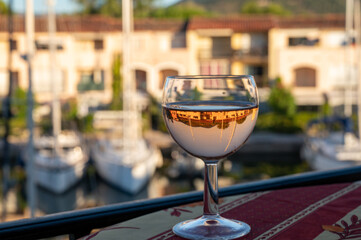 Drinking of local rose wine in summer with sail boats haven of Port Grimaud on background, Provence, France