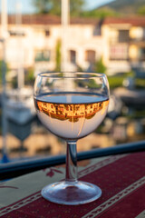Drinking of local rose wine in summer with sail boats haven of Port Grimaud on background, Provence, France