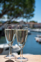 Summer party with sparkling champagne wine and sail boats haven of Port Grimaud on background, Provence, France