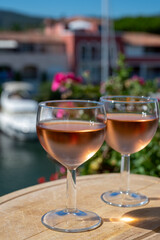 Tasting of local rose wine in summer with sail boats haven of Port Grimaud on background, Provence, France
