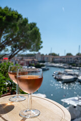 Tasting of local rose wine in summer with sail boats haven of Port Grimaud on background, Provence, France