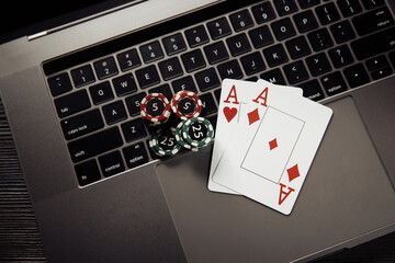 Online poker casino theme. Gambling chips and playing cards on keyboard.