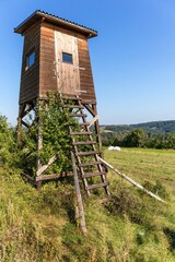 Fototapeta na wymiar Hunting tower in nature,Czech Republic. Lookout tower for hunting in summer day. Agricultural landscape in the Czech Republic. A place for hunting wildlif