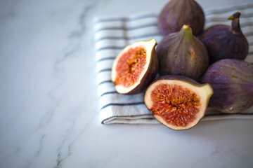 Fresh ripe figs as background, top view. Tropical fruit. Fresh ripe figs with green leaf and on table background. Healthy Mediterranean fig fruit. Beautiful blue-violet figs 