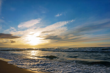 Sunset over the sea. Reflection of sunlight in the sea waves. The sky in the sunset rays.