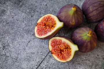 Fresh figs. Food Photo. whole and sliced figs on beautiful rustic background. Fresh Organic Figs.  Healthy Mediterranean fig fruit. Beautiful blue-violet figs with empty copy space close up.