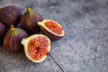 Fresh figs. Food Photo. whole and sliced figs on beautiful rustic background. Fresh Organic Figs.  Healthy Mediterranean fig fruit. Beautiful blue-violet figs with empty copy space close up.